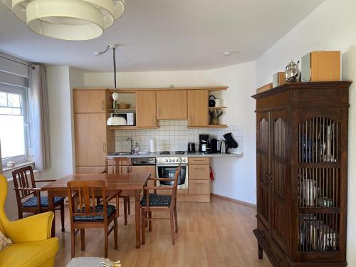 a kitchen with a wooden table and a dining room at Ferienwohnung H 25 "Tausendschön" in Graal-Müritz