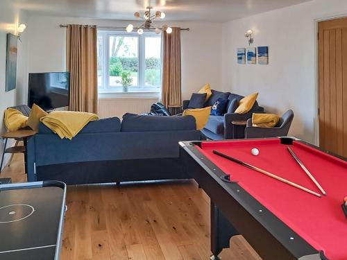 a living room with a couch and a pool table at Riverside in Wimblington