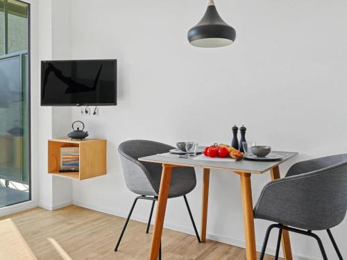 a dining room with a table and chairs and a television at Apartment Seebrise by Interhome in Lembruch