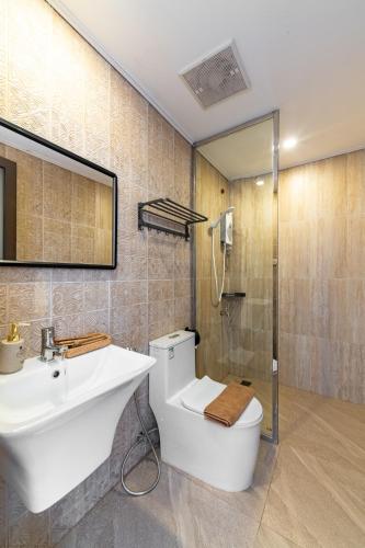 a bathroom with a toilet and a sink and a shower at The Jam Central in Luang Prabang