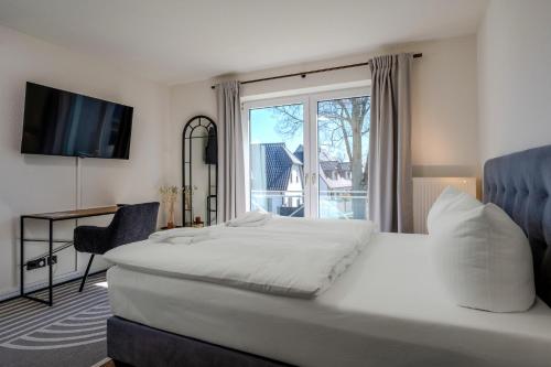 a bedroom with a bed and a large window at Johouse Zingst Johouse Zimmer 07 in Zingst