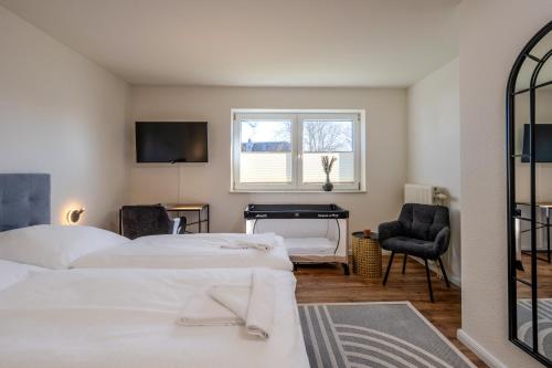 a bedroom with two beds and a desk and a window at Johouse Zingst Johouse Zimmer 09 in Zingst