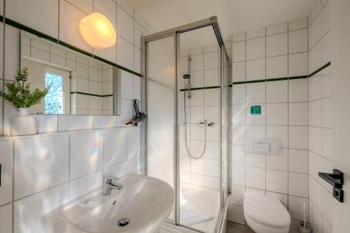 a white bathroom with a shower and a sink at Johouse Zingst Johouse Zimmer 21 in Zingst