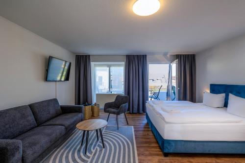 a hotel room with a bed and a couch at Johouse Zingst Johouse Zimmer 21 in Zingst