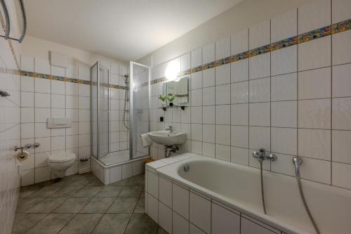 a bathroom with a tub and a sink and a toilet at Johouse Zingst Johouse Zimmer 15 in Zingst