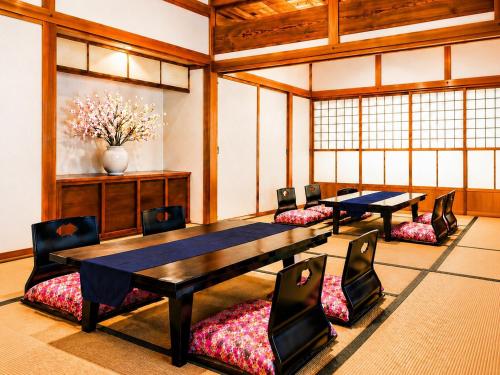 a conference room with two tables and chairs and a vase at 里や 糸島 川遊び Bbq 花火を楽しむ古民家1棟貸し in Itoshima