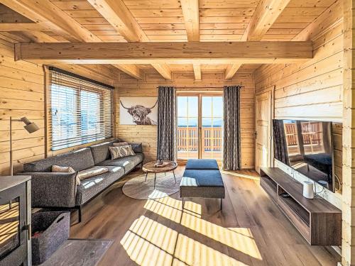 a living room with a couch and a large window at Chalet Nockhütte by Interhome in Hochrindl