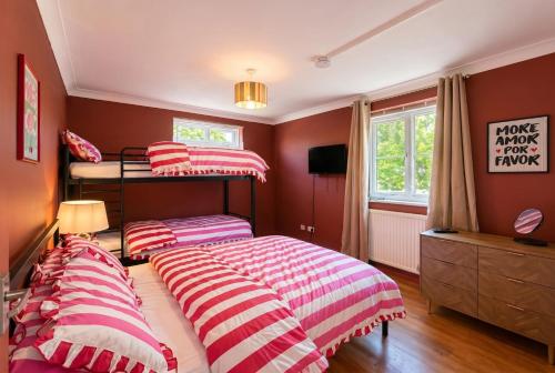 two bunk beds in a bedroom with red walls at Central Brockenhurst Village Flat with Free Parking in Brockenhurst