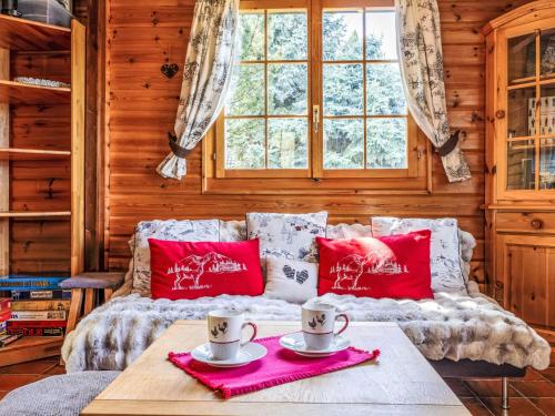 a living room with a couch and two cups on a table at Chalet Chalet Le Trèfle by Interhome in Salins