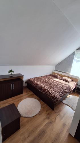 a bedroom with a bed and a wooden floor at Casa de vacanta Bulz in Bulz