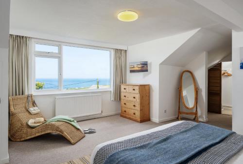 a bedroom with a bed and a large window at Boskenna in Tintagel