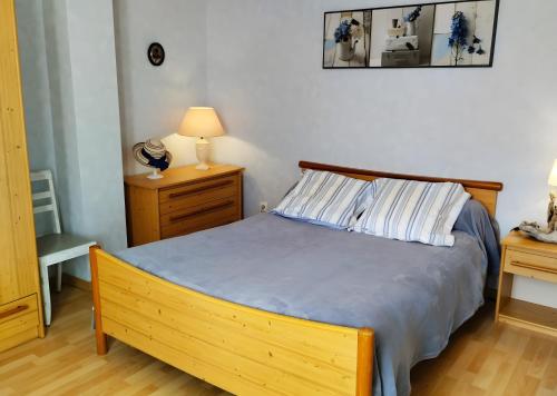 a bedroom with a wooden bed and two night stands at Gîte Pyrénées Ariège Ustou in Ustou