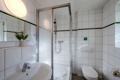a bathroom with a shower and a sink and a toilet at Johouse Zingst Johouse Zimmer 18 in Zingst