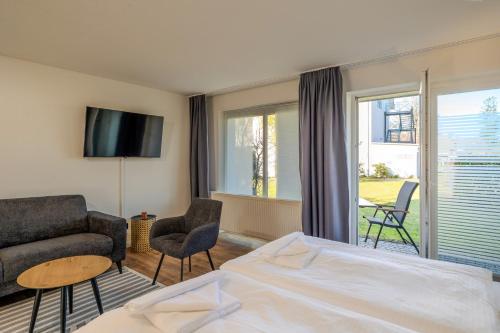 a hotel room with a bed and a living room at Johouse Zingst Johouse Zimmer 18 in Zingst