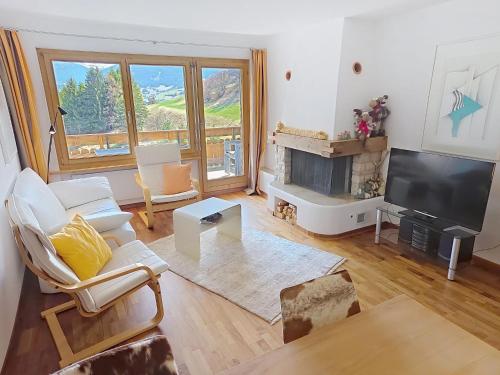a living room with a fireplace and a tv at Apartment Toissa A6 by Interhome in Salouf