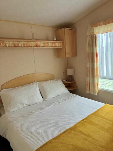 a bedroom with a bed and a window at Bardsey View Holiday Park Nr New Quay in Llanarth