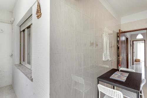a bathroom with a black counter and a mirror at Almada Central by Homing in Almada