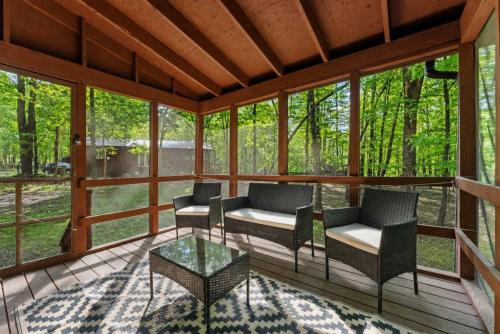 a screened porch with chairs and a glass table at DogFriendly wHot Tub Fire Pit Resort Access in Hedgesville