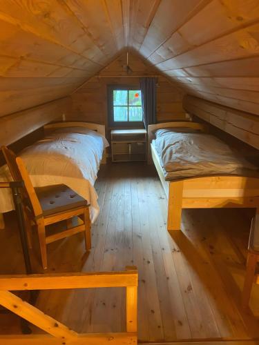 two beds in a wooden cabin with a window at Ferienhaus 'am Eulennest' in Jabel