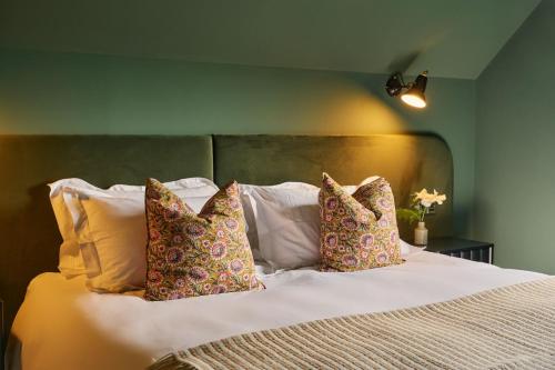 ein Schlafzimmer mit einem weißen Bett und vier Kissen in der Unterkunft Grain Loft in Trefeglwys