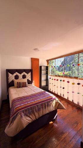 a bedroom with a bed and a large window at Mayupata home in Cusco