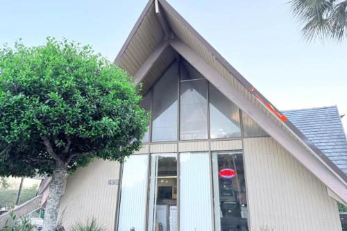 a building with glass windows and a tree in front of it at Campus Inn by Hotel O Gainesville - University Area in Gainesville