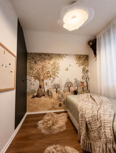 a bedroom with a tree mural on the wall at La Casa Kiara - Heated Pool, Jacuzzi & Forest View in Stubicke Toplice