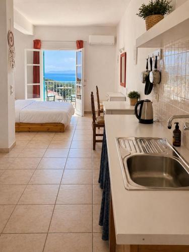 a kitchen with a sink and a bedroom with a bed at Casa Spartines in Votsi