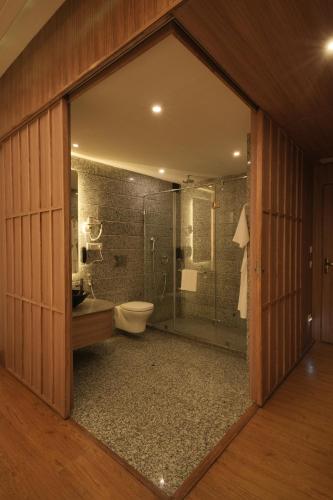 a bathroom with a toilet and a glass shower at Clarks Amer in Jaipur