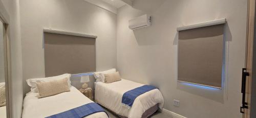 a small room with two beds and a window at Sky & Sea in St. Helena Bay