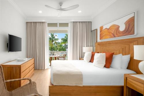 a bedroom with a bed and a desk and a television at Alexandra Resort - All-Inclusive in Providenciales