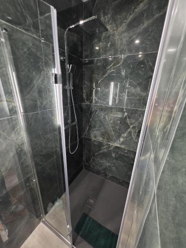 a shower with a glass door in a bathroom at Doré in Carhaix-Plouguer