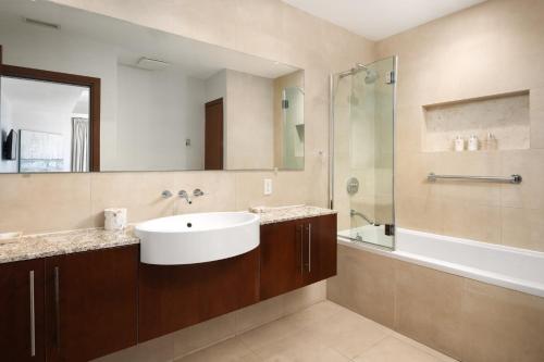 a bathroom with a sink and a shower and a tub at Blue Haven Resort- All Inclusive in Providenciales