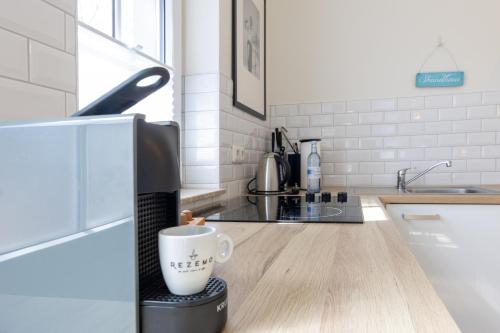 a coffee cup sitting on top of a counter in a kitchen at Boutique-Hotel STRANDHAUS Ahrenshoop in Ahrenshoop