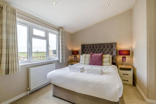 a bedroom with a large bed and two windows at Primrose 1 bed -No Pets-Rose in Eye