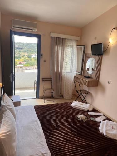 a bedroom with a large bed and a large window at Isidora Hotel in Agia Marina Aegina