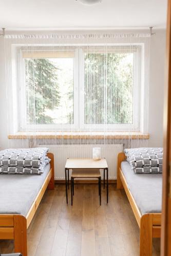 a room with two beds and a table in it at Kwatery Fado in Częstochowa