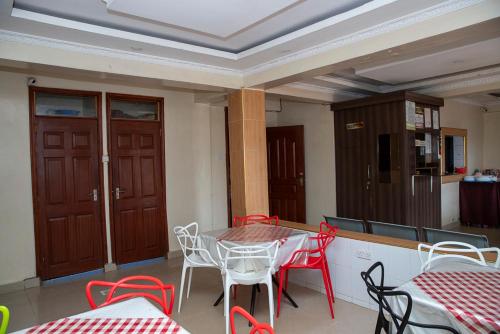 a dining room with red and white tables and chairs at ST Augustine Hotel Ltd in Kisumu