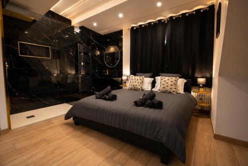 a bedroom with a large bed and a black wall at La Bulle Prestige in Montargis