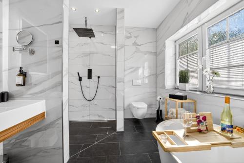 a white bathroom with a shower and a toilet at JUNIPRO Luxury Apartments in Bosen-Eckelhausen