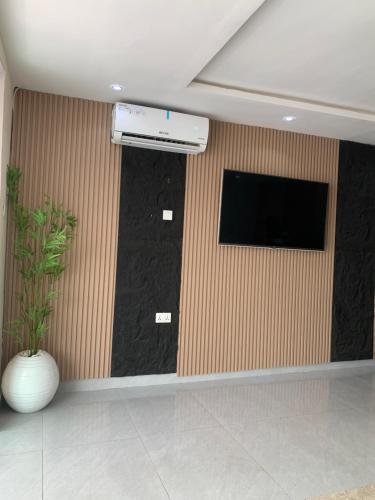 a room with a flat screen tv and a wall at Kris Courts in Ibadan