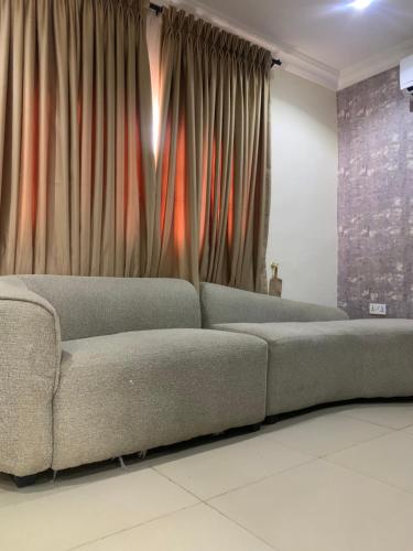 a couch in a living room with curtains at Kris Courts in Ibadan