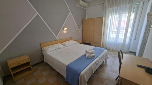 a bedroom with a bed with a teddy bear on it at Hotel Astoria in Riccione