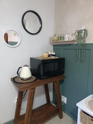 a microwave on a wooden table in a kitchen at Bluewater Guesthouse in Port Elizabeth