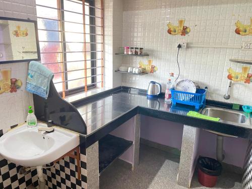 a bathroom with a sink and a counter top at R J Homestay in Māvalli
