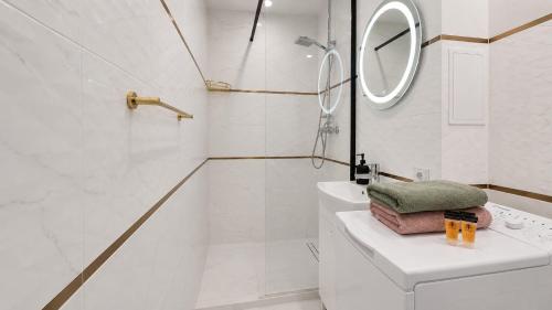 a white bathroom with a sink and a mirror at Albatros Apartment Stogi in Gdańsk