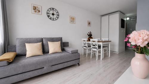 a living room with a gray couch and a table at Albatros Apartment Stogi in Gdańsk