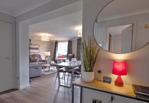 a living room with a table and a mirror at Finest Retreats - Gleneagles in Auchterarder