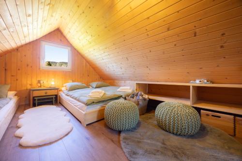 a room with a bed and two chairs in a attic at Hiška Janko in Bohinjska Bistrica
