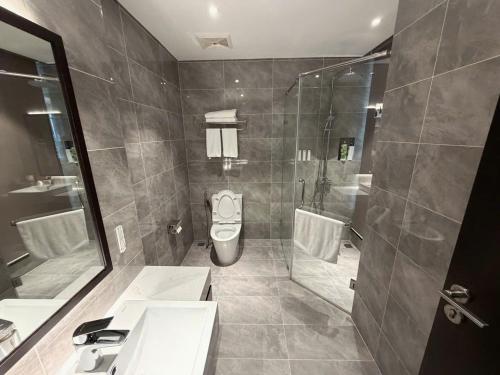 a bathroom with a shower and a sink and a toilet at Sapphire Hạ Long Luxury Studio in Ha Long